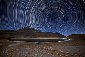   Science and art unite in this beautiful photograph, taken in Chile’s Atacama Desert by ESO Photo Ambassador Adhemar M. Duro Jr. To create this visual masterpiece Adhemar pointed his camera at the sky’s south pole, the point at the centre of all the bright arcs and circles. All the stars in the night sky revolve around this point. Over a period of several hours, this motion creates star trails, with each individual star tracing out a circle on the sky. These trails display the various brightnesses and colours of each star, creating a captivating scene! Towards the top left of the image, you can see a short, bright streak of light cutting across the trails — this is caused by a meteor, burning up in a flash of light as it enters Earth’s atmosphere. The desert’s harsh and arid landscape, illuminated here by the light from the stars themselves, is the perfect place to view the night sky. Because of the location’s favourable conditions several telescopes are hosted here, including ESO’s Very Large Telescope, ESO’s Visible and Infrared Survey Telescope for Astronomy (VISTA), and the forthcoming European Extremely Large Telescope, which is currently under construction atop Cerro Armazones.